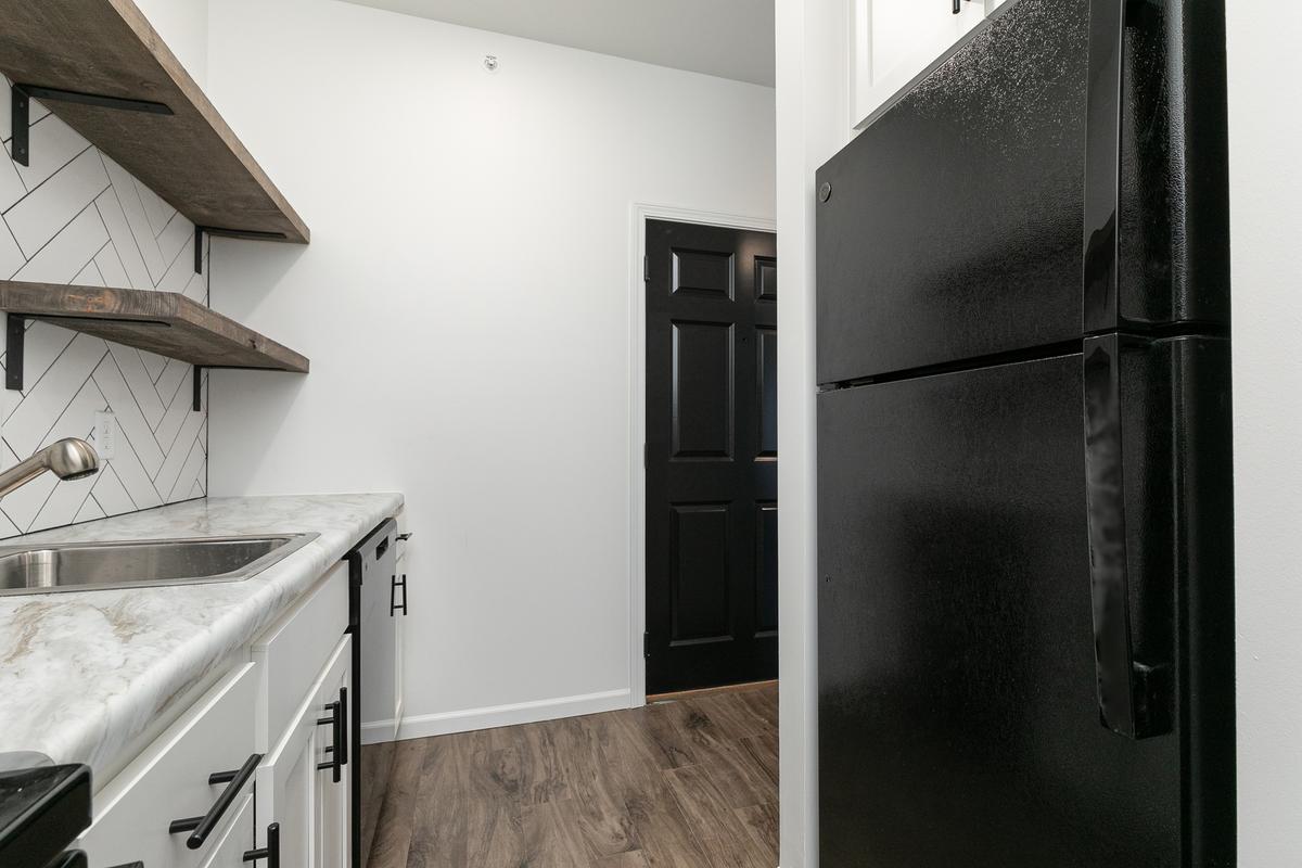 Vacant kitchen counter and sink with the black refrigerator