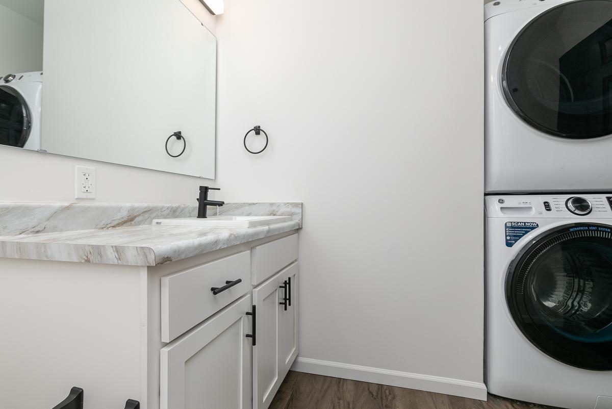 Vacant bathroom vanity with the stacked washer and dryer beside it