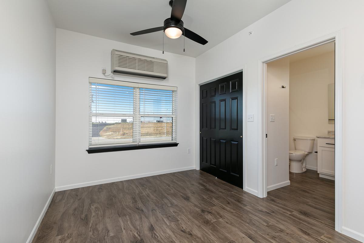 Vacant sleeping area with window and the bathroom through the door