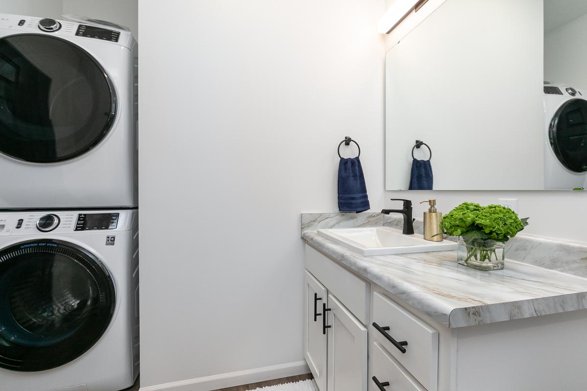 Stacked washer and dryer beside the bathroom vanity
